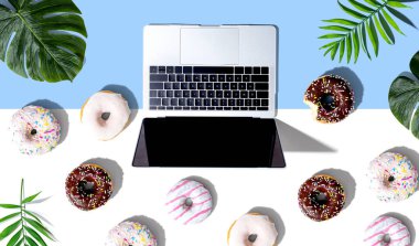 Çörekleri ve tropikal bitkileri olan bir laptop.