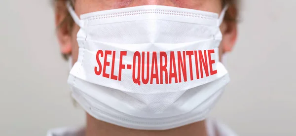 Self-quarantine theme with person wearing a protective face mask