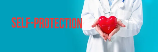Θέμα αυτοπροστασίας με ένα γιατρό που κρατά μια καρδιά — Φωτογραφία Αρχείου