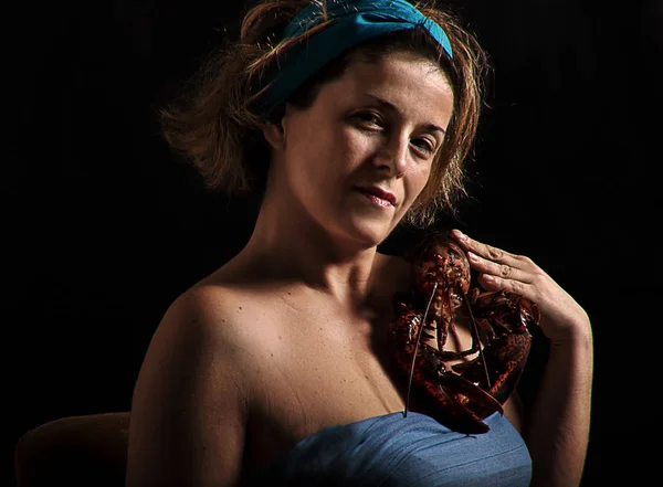 woman holding lobster at her shoulder
