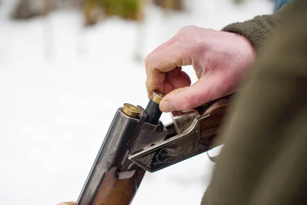 man with rifle in winter forest