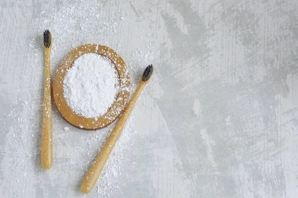 bamboo eco friendly toothbrushes and tooth powder, zero waste tooth cleaning set on concrete background