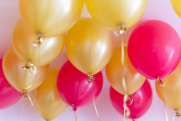 red and gold balloons with helium under the ceiling for a birthday party