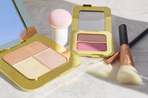 premium makeup brushes, sponge and blush pads on a light marble background, creative cosmetics flat lay