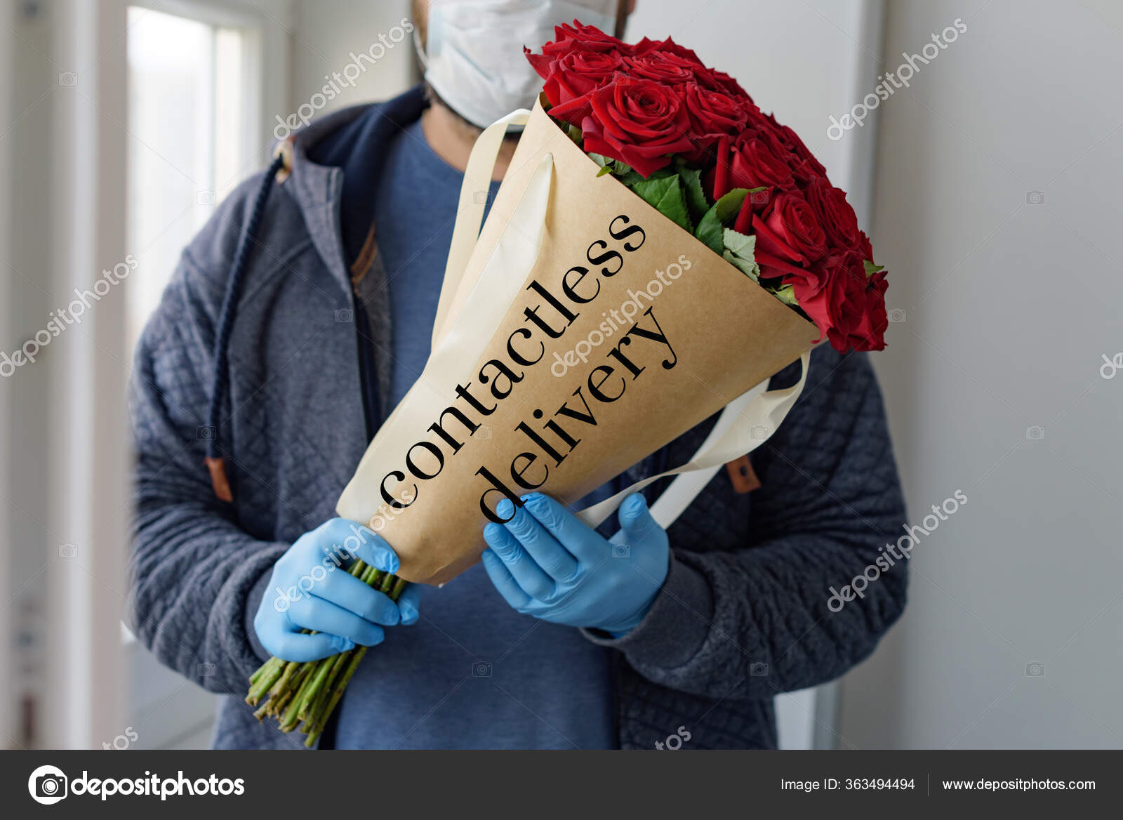 无接触式送花男性送花员戴着防护面罩医用手套配一束红玫瑰花业衰败的概念 图库照片 C Klavdiyav