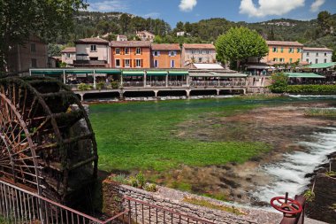 Fontaine-de-Vaucluse, Provence-Alpes-Cote d 'Azur, Fransa: Yeşil Sorgue nehri ve su değirmeni tekerleği olan köyün manzarası