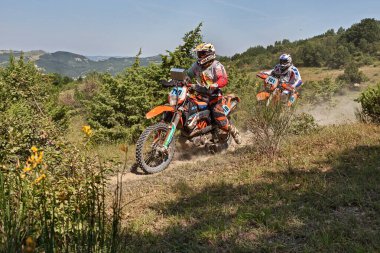 Bikers riding enduro motorcycles KTM 690 Enduro R and KTM EXC 450 during the Italian championship Motorally Terre di Romagna, on July 5, 2015 in Predappio, FC, Emilia-Romagna, Italy clipart