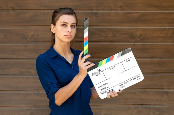 Bella ragazza con un cracker cinematografico. Assistente alla regia con un cracker su sfondo marrone — Foto Stock