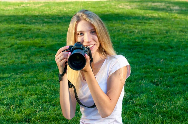 白い髪の女の子の写真の肖像画。ティーンエイ ジャーは、彼の手と笑顔でカメラを保持します。. — ストック写真