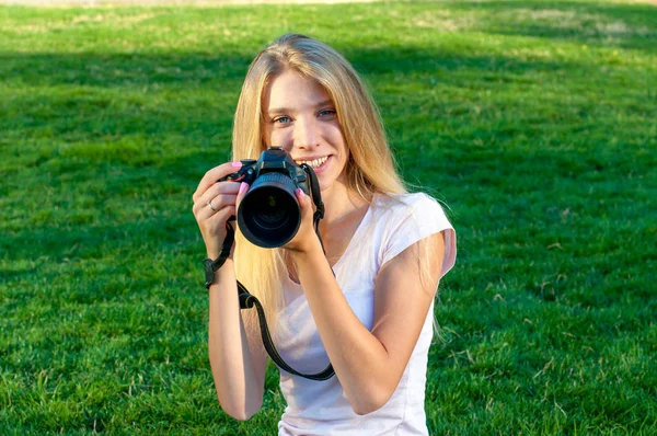 Porträtt av en flicka fotograf med vitt hår. Tonåringen håller kameran i händerna och leenden. — Stockfoto