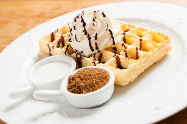 Belgian waffel with cream chocolat sauce and sugar served in a restaurant — Stock Photo, Image