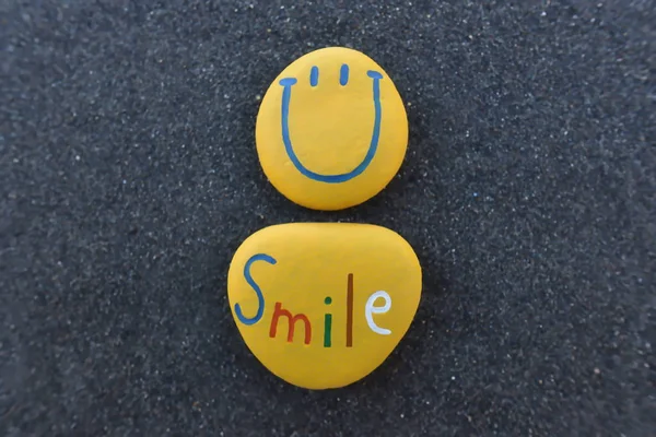 Happy Smiley Emoticon design con pietre colorate su sabbia vulcanica nera — Foto Stock