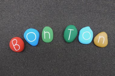 Çok renkli taşların siyah volkanik kum üzerinde metinle Bon Ton