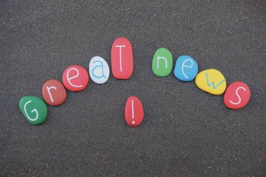 Harika bir haber kavramı ile çok renkli taşların siyah volkanik kum üzerinde