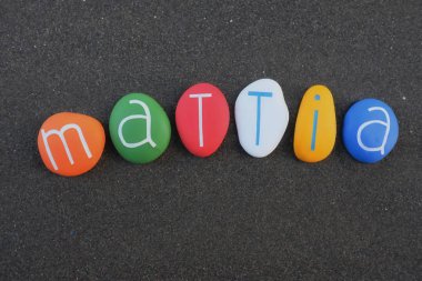 Mattia, erkeksi bir isim. Siyah volkanik kumların üzerine çok renkli taş harflerle yazılmış.