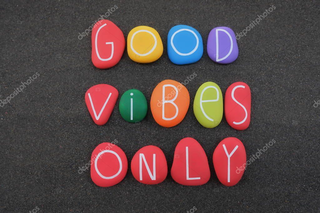 Good Vibes Only, positive phrase for a better life composed with multi colored stone letters over black volcanic sand