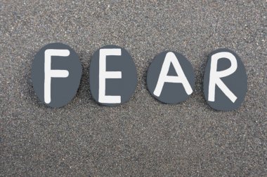 Volkanik kumun üzerine siyah renkli taş harflerle yazılan korku kelimesi.