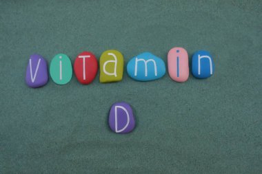 D vitamini metni yeşil kum üzerinde çok renkli taş harflerle oluşturuldu
