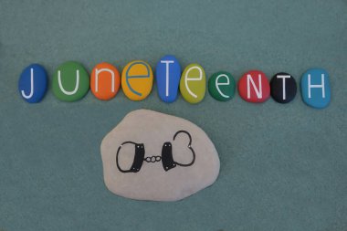 Birleşik Devletler 'de köleliğin sona ermesinin ulusal çapta en eski anıtı olan Juneteenth, yeşil kumların üzerinde çok renkli taş harflerle yazıldı.