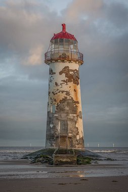 Eski bir kullanılmayan deniz feneri sabah erken güneş ışığı ile sahilde bir dik dikey görüntü