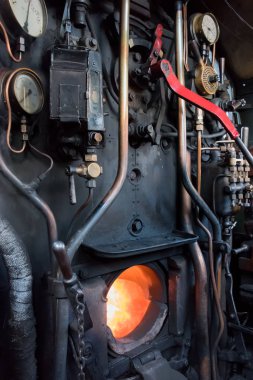 bir eski buharlı lokomotif tren Yangın kutusu alevler gösterilen açık sürüş denetimlerini içine dik biçimi