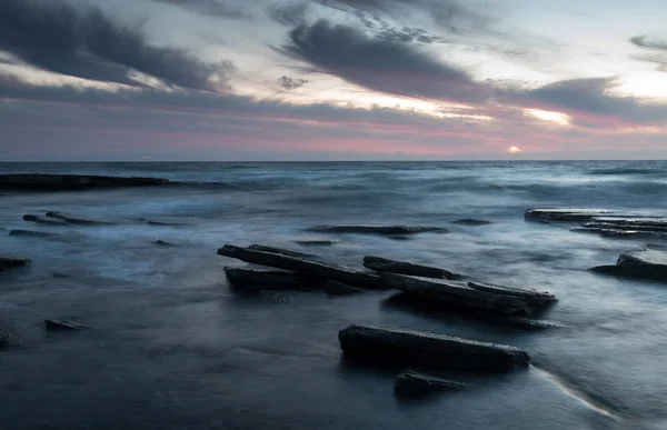 Zachód słońca na skalistej plaży — Zdjęcie stockowe