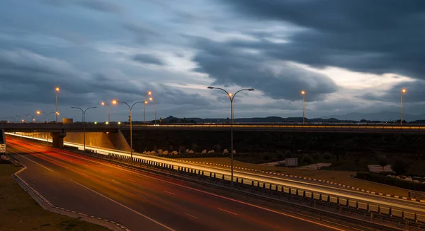 Lichte trails van snel bewegende auto's op een snelweg — Stockfoto