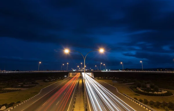 Trilhas leves de carros em movimento rápido em uma estrada — Fotografia de Stock