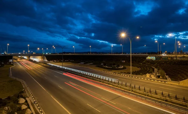 Φως μονοπάτια από γρήγορα αυτοκίνητα κινούνται σε αυτοκινητόδρομο — Φωτογραφία Αρχείου