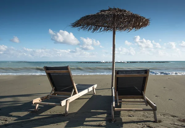 Parasols et chaises longues sur une côte sablonneuse vide — Photo