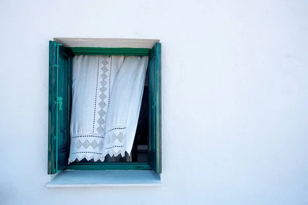 Offenes grünes Fenster an einer weißen Wand — Stockfoto