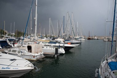 Kıbrıs 'taki Larnaka marinasına demirlemiş yatlar fırtınalı bulutlu gökyüzüyle