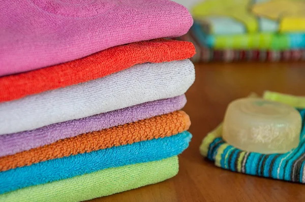 Asciugamani variopinti in una pila e un sapone . — Foto Stock