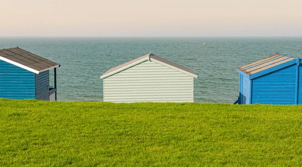 Színes nyaralás fa strand kunyhók szemben a nyugodt óceán. — Stock Fotó