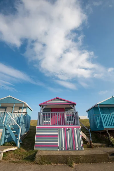 Кольорові дерев "яні пляжні хатинки, що стоять обличчям до океану біля узбережжя Вітстебля. — стокове фото