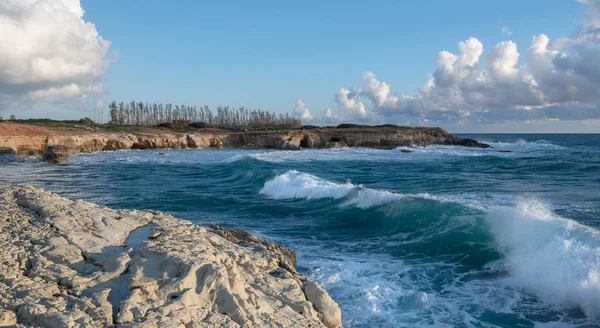 Las olas del mar salpicando en las rocas de una playa rocosa — Foto de Stock