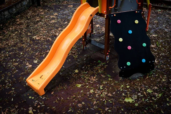 Aire de jeux vide pour enfants avec des jouets colorés et des feuilles sur le — Photo