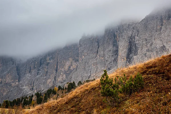 Dolomite mountain peaks covered in fog during sunrise — Stock Photo, Image