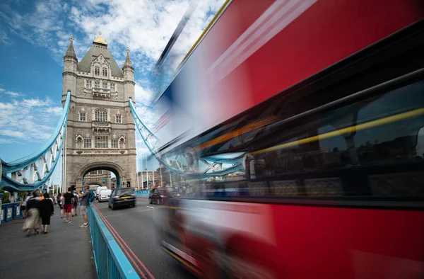 Gente caminando y rojo tradicional autobús de Londres cruzando el famou — Foto de Stock