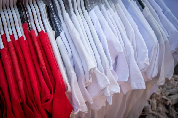 Camisetas casuales rojas y blancas en una percha para la venta —  Fotos de Stock