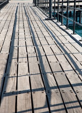 Ahşap bir iskelede çizgiler ve gölgeler.