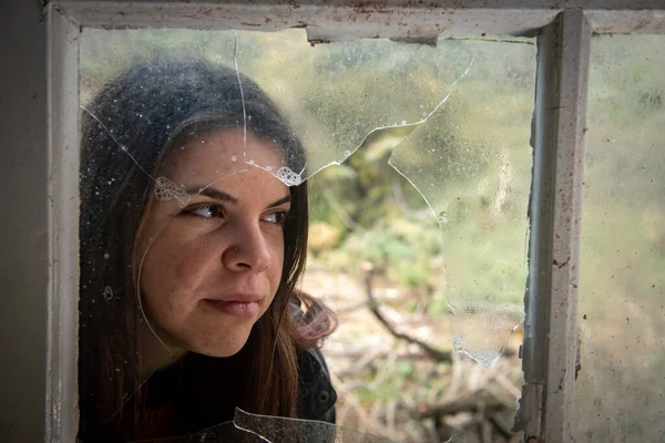 Kırık Bir Pencerenin Arkasında Poz Veren Güzel Bir Kadın — Stok fotoğraf