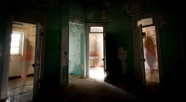 キプロスの放棄された不気味な病院の部屋のドアを開けて一人で歩いている認識されていない人のシルエット — ストック写真