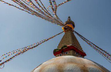 Boudha Stupa, Nepal 'in Katmandu şehrinde mavi gökyüzüne karşı, dinsel renkli bayraklar dalgalanıyor..