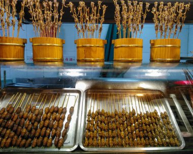 Çubuğun üzerinde Çin 'in Pekin' deki çerez sokağında yenmeye hazır lezzetli akrepler var. Asya mutfağı