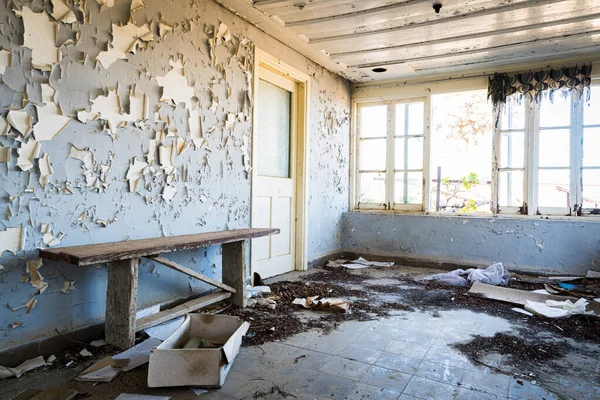 損傷した家具の乱雑な床と窓からの明るい日差しと古い放棄されたオフィスの寝室のインテリア — ストック写真