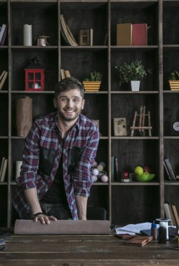 Genç adam deri işçi iş Studio ahşap masa üzerinde deri ile başlar