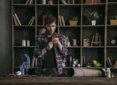 Yakışıklı deri üreticisi ayakta tablo önünde ve iş bitirme