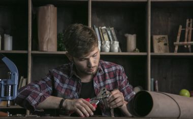 Genç deri üreticisi hassas çalışma aracı delik zımba ile adam.