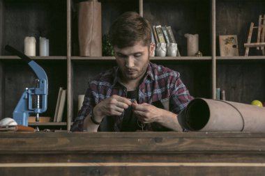 Deri üreticisi dikiş çanta beyaz iplik ile genç adam